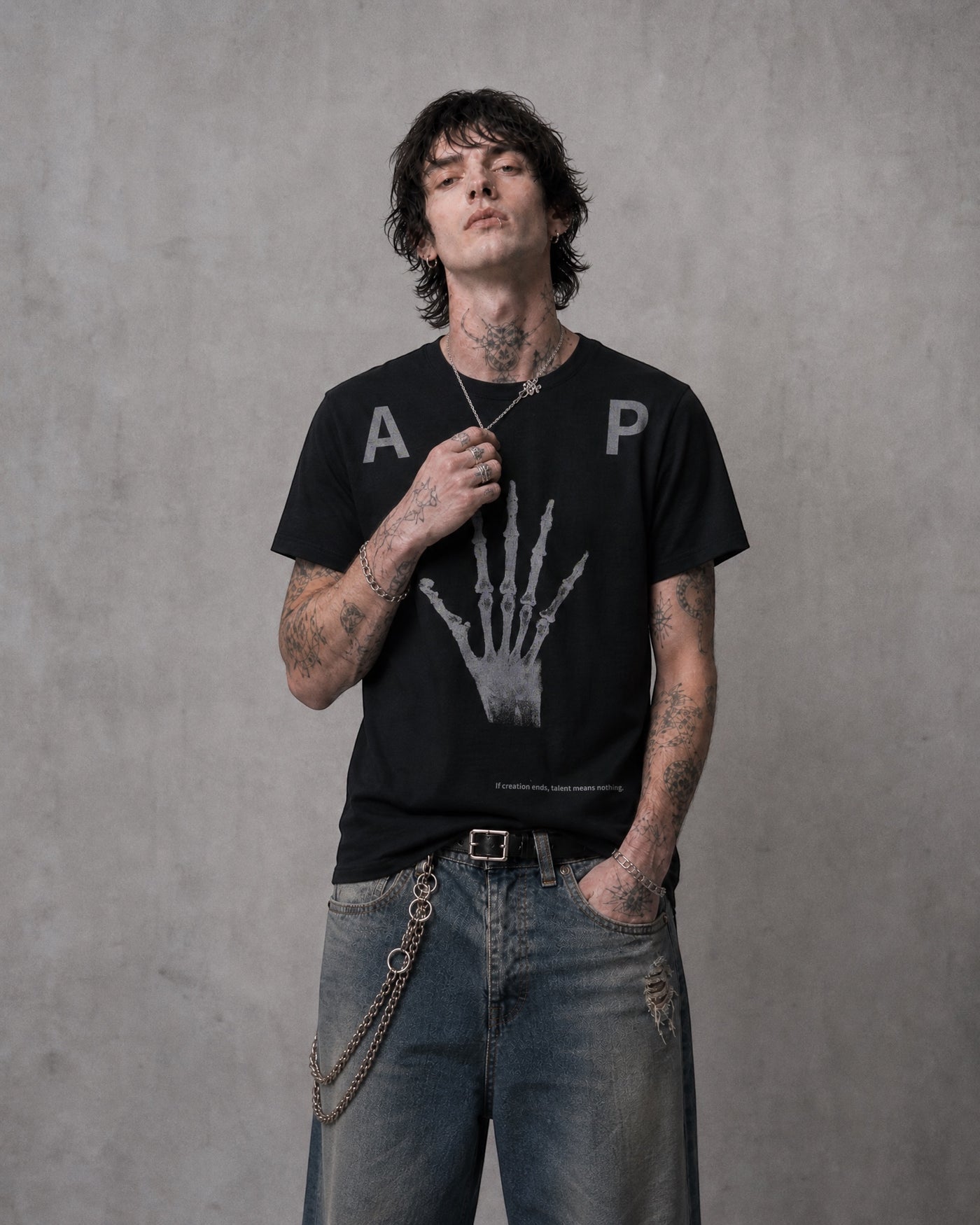ANTIPROMINDの黒い天竺コットンTシャツ。フロントにスケルトンハンドのグラフィックがプリントされたリラックスフィットのヴィンテージ風デザイン。