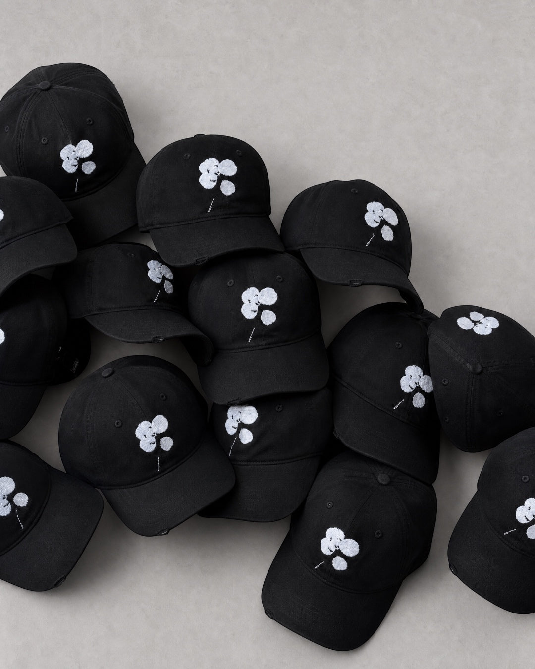 ANTIPROMINDのクローバーロゴが刺繍された黒いコットン製キャップの集合写真