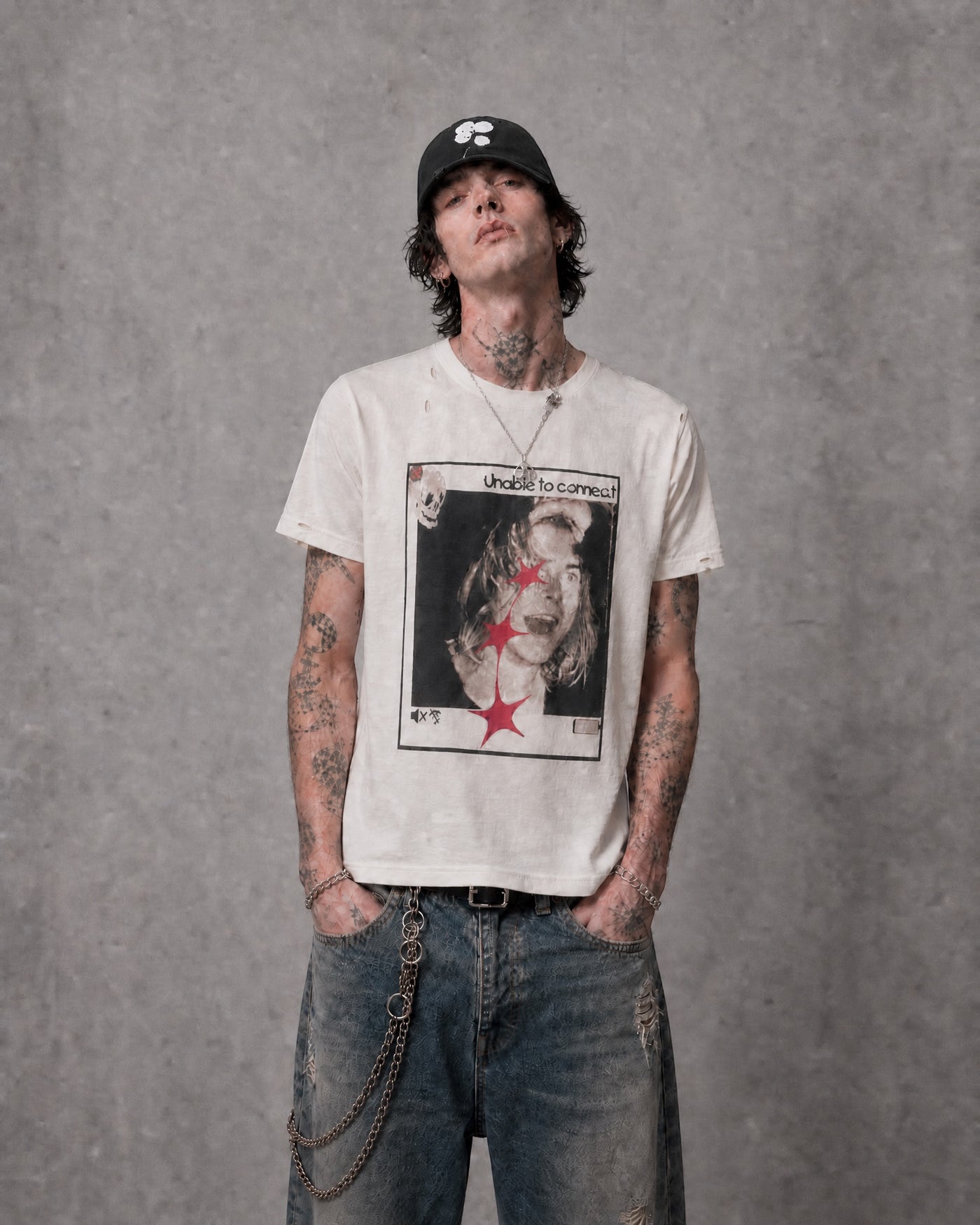 ANTIPROMINDのダメージ加工が施されたヴィンテージ風グラフィックTシャツを着用した男性モデル